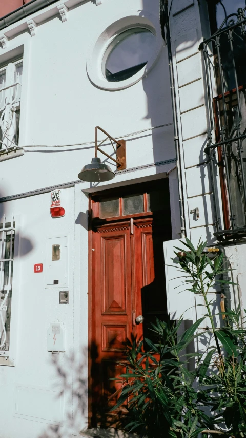a white house with a red door and window, by Niko Henrichon, pexels contest winner, art nouveau, gif, istanbul, low quality photo, brown