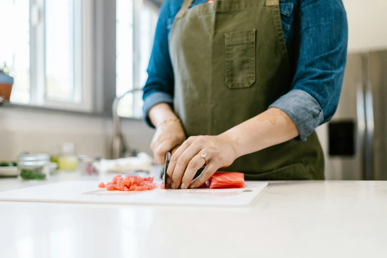 a woman in an apron chopping tomatoes on a cutting board, pexels contest winner, private press, flowing salmon-colored silk, 🦩🪐🐞👩🏻🦳, dwell, box cutter