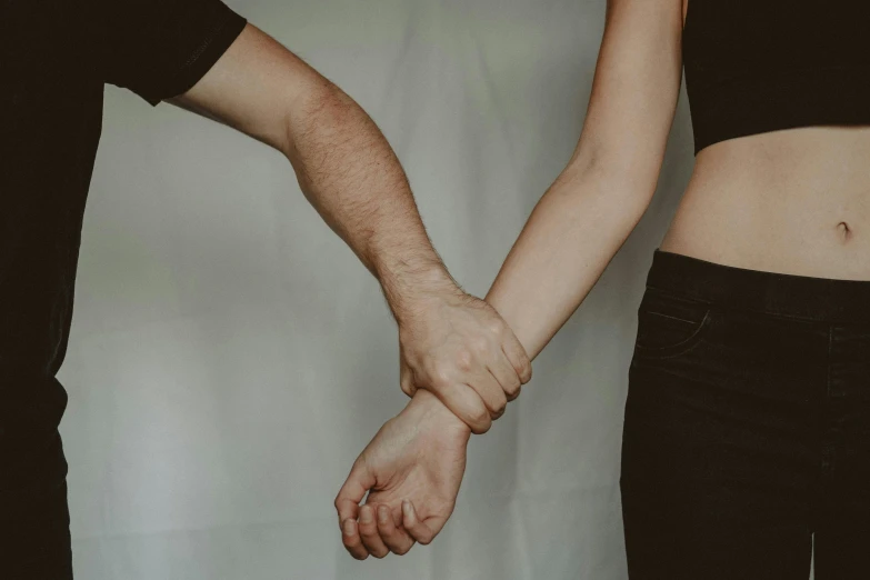 a man and a woman holding hands, by Emma Andijewska, trending on pexels, bandage on arms, plain background, connecting lines, best friends