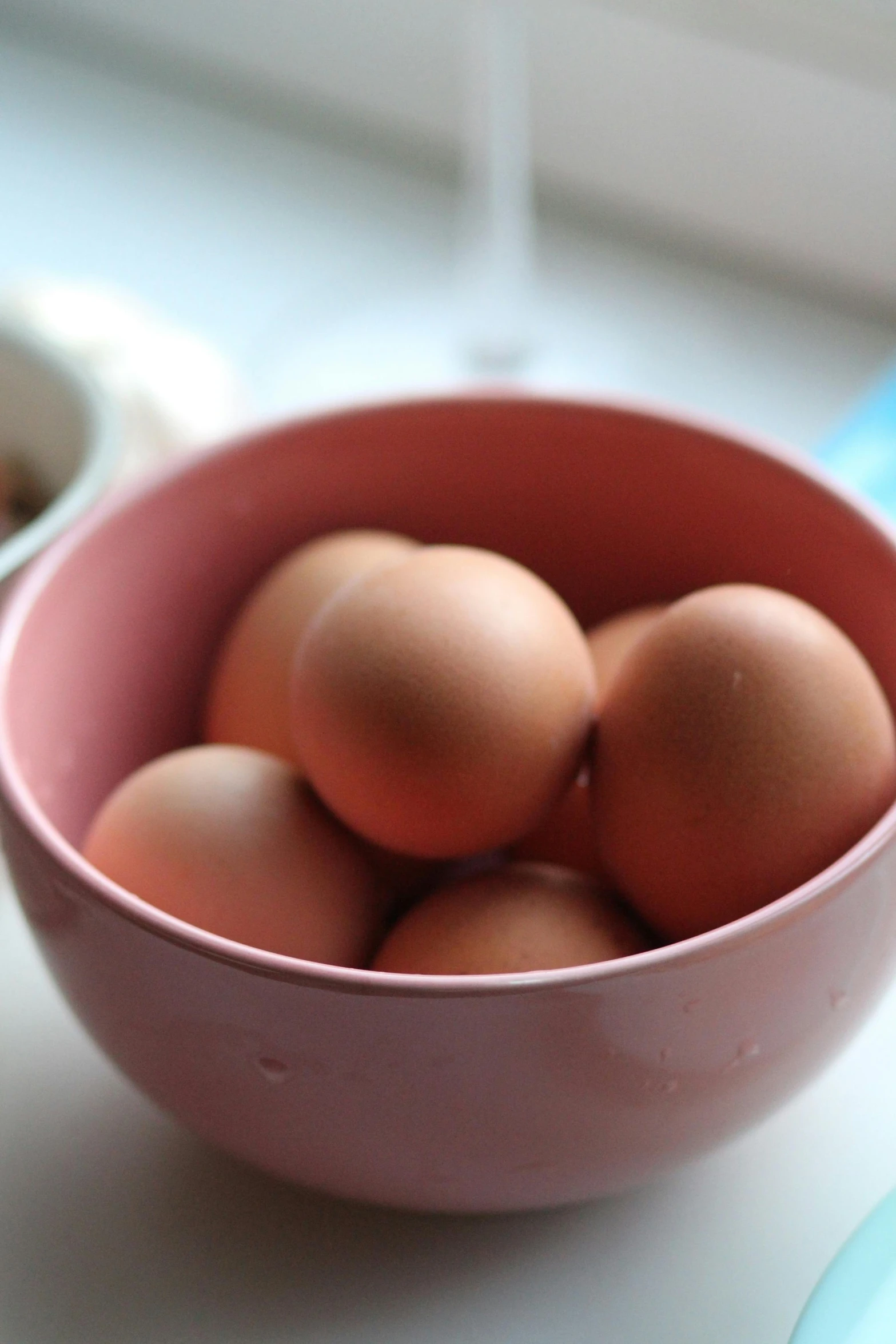 a pink bowl filled with eggs sitting on top of a counter, a picture, 6 : 3 0 am, upclose, brown ) ), large)}]