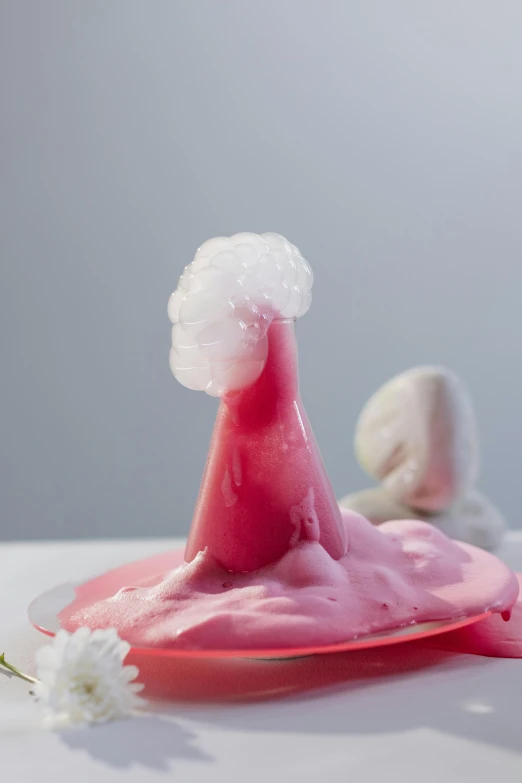 a pink cake sitting on top of a white table, a surrealist sculpture, by Doug Ohlson, reddit, plasticien, an ice volcano, pointy conical hat, freeform ferrofluids, close up food photography