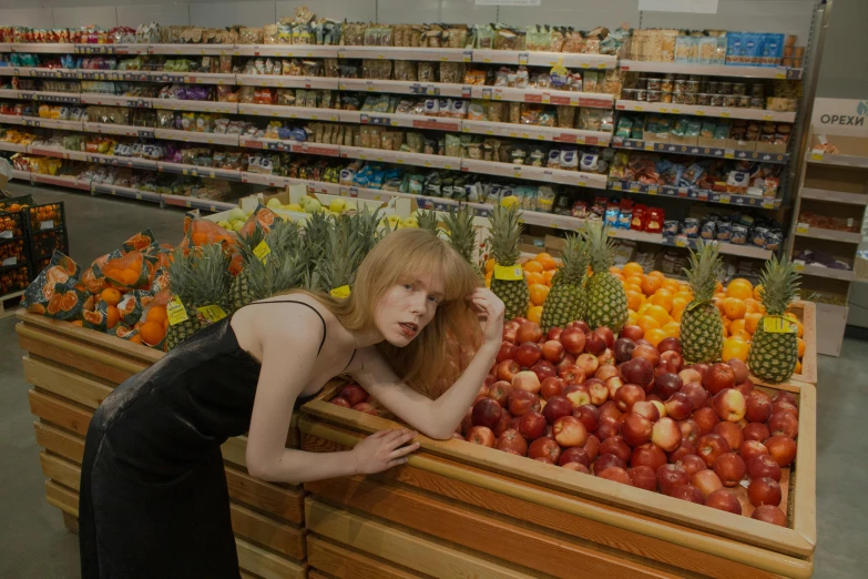 a woman leaning over a fruit stand in a grocery store, an album cover, inspired by Nan Goldin, pexels, hyperrealism, sophia lillis, portrait of kim petras, ilya kushinov, ellie bamber