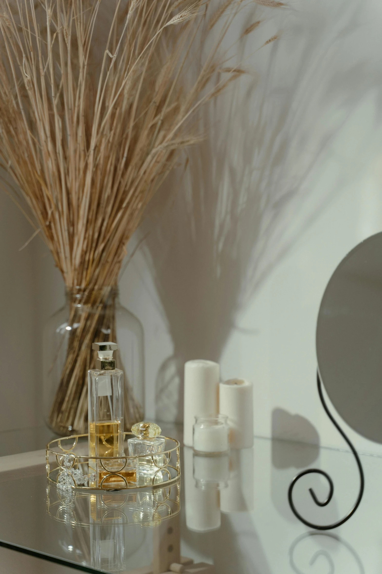 a mirror sitting on top of a glass table, perfume bottle, hay, natural candle lighting, detail shot