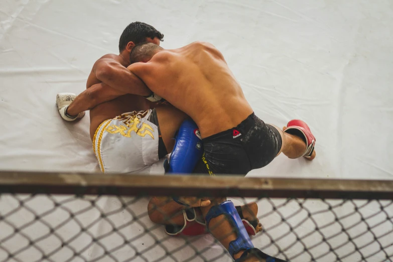 a couple of men standing next to each other on a wrestling ring, pexels contest winner, netting, two muscular men entwined, a high angle shot, resting after a hard fight