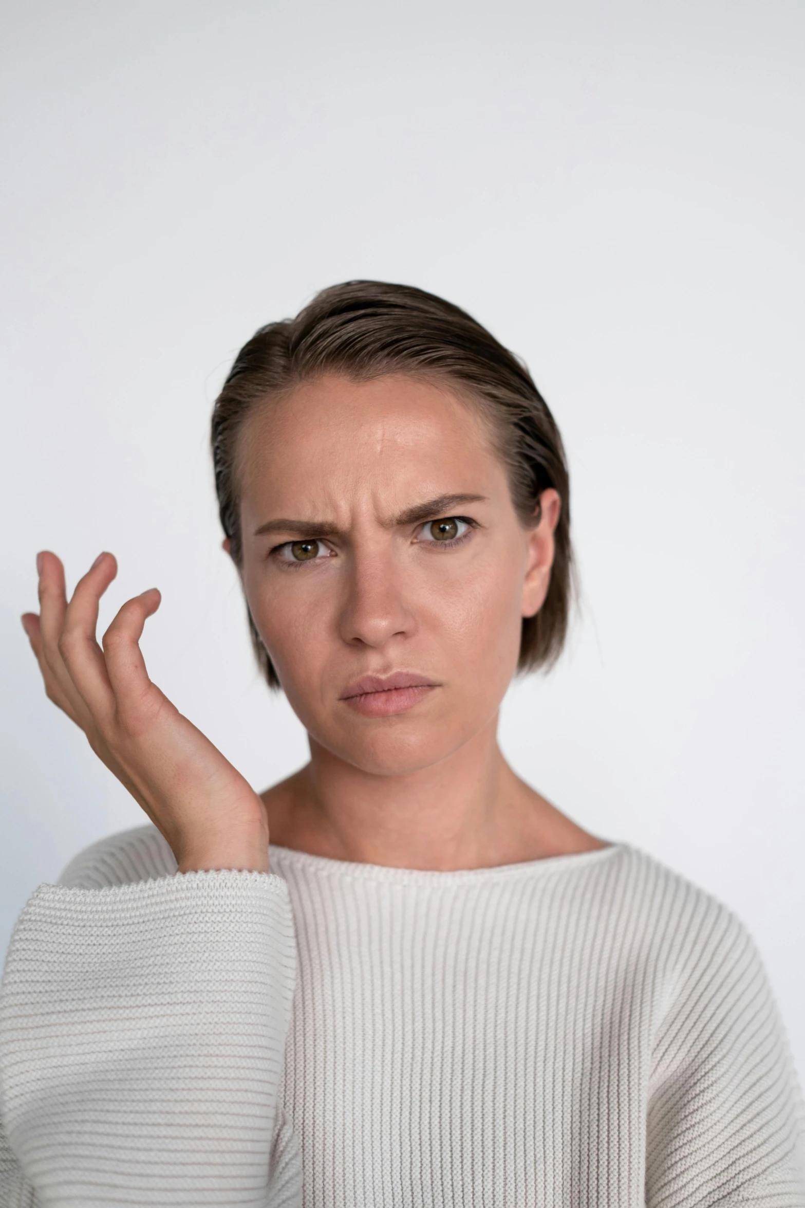 a woman with a concerned look on her face, a colorized photo, trending on pexels, angry and pointing, non binary model, high forehead, hand gesture