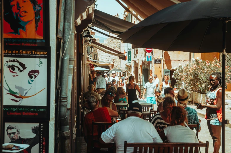 a group of people sitting at tables under umbrellas, pexels contest winner, happening, french village interior, shady alleys, thumbnail, sunny day time