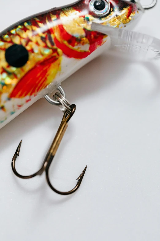 a close up of a lure on a hook, trending on pexels, process art, with a white background, foil, japanese collection product, patterned