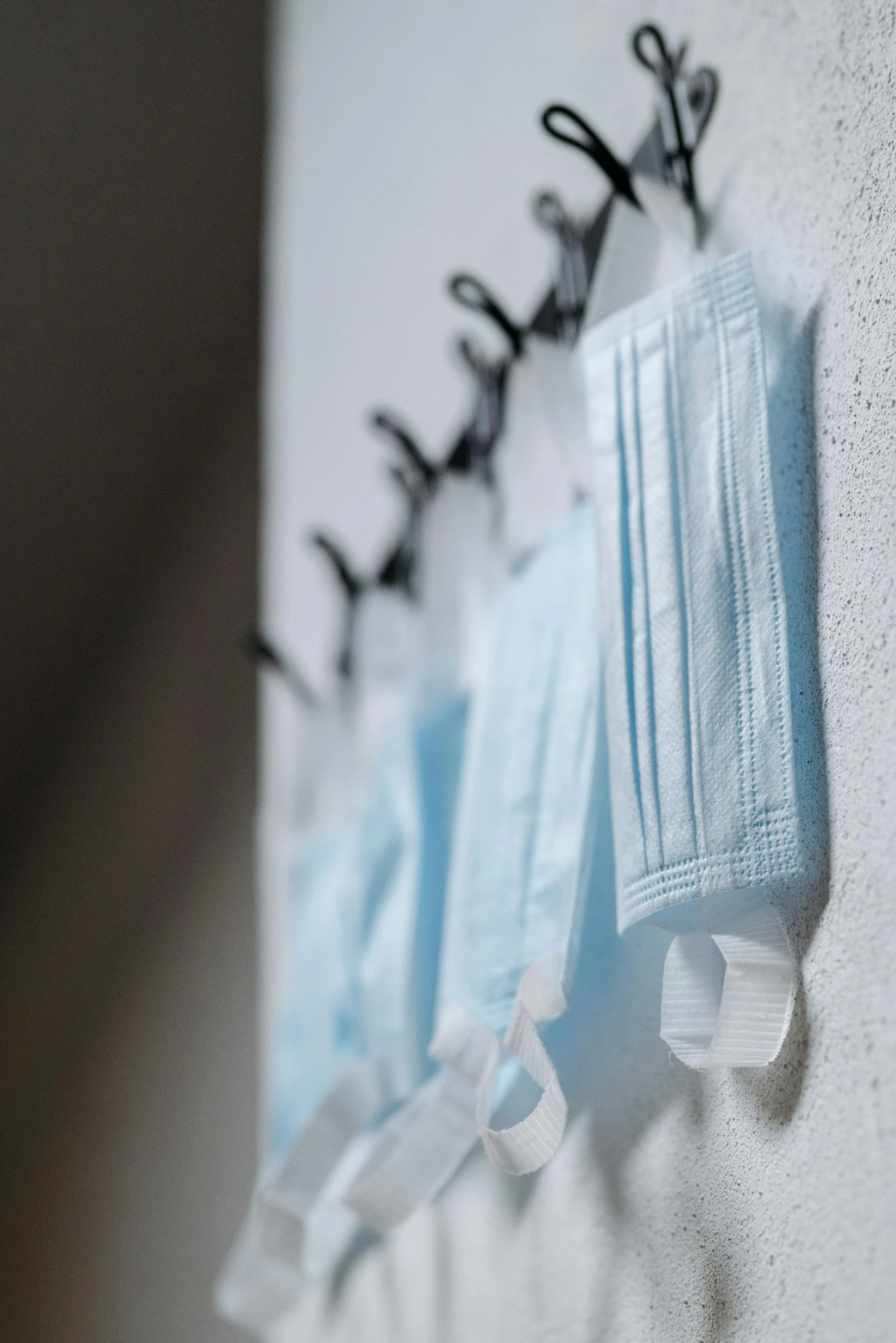 a pair of surgical masks hanging on a wall, by Daniel Lieske, unsplash, happening, in a row, light blues, thumbnail, harnesses