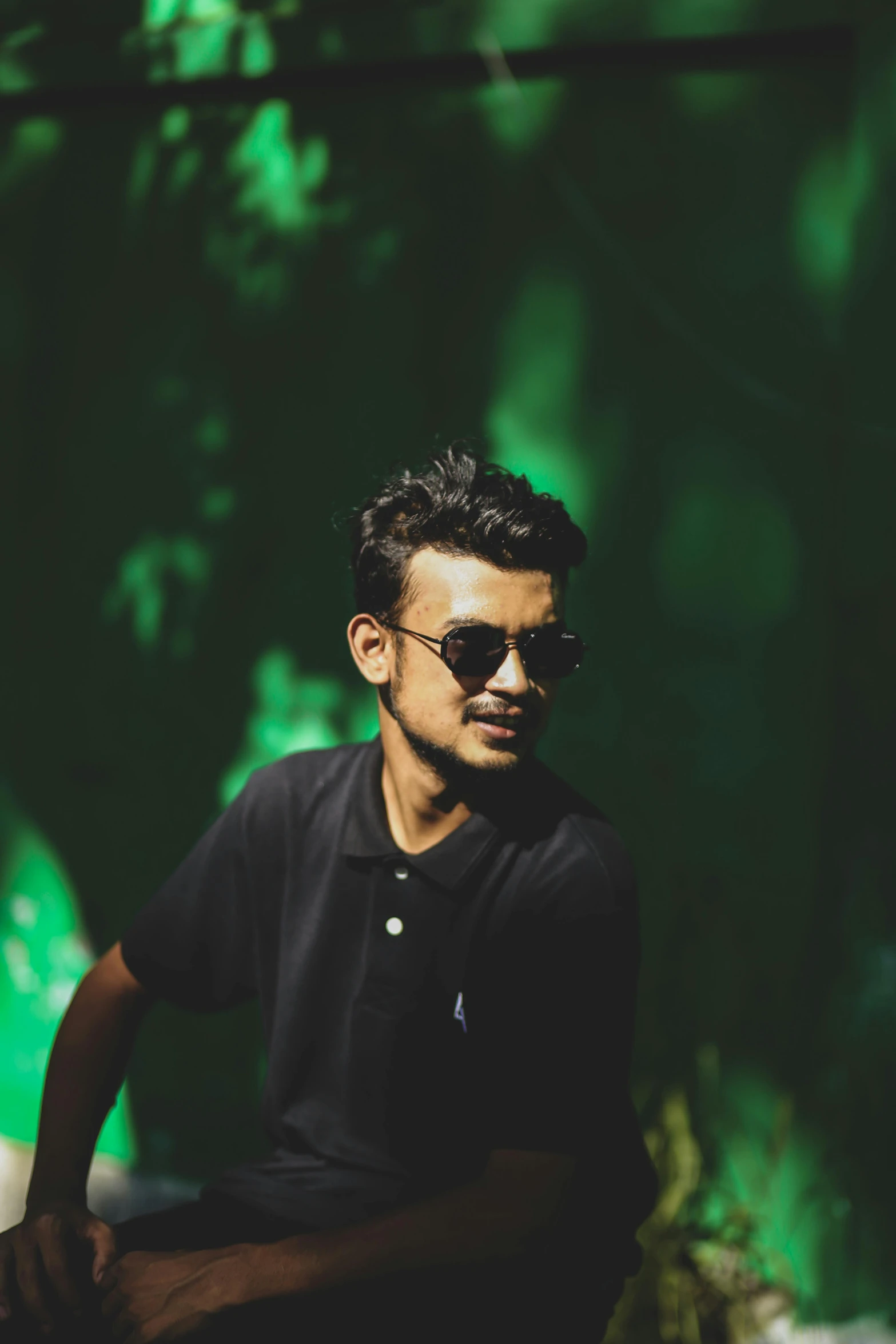 a man sitting in the shade of a tree, by Max Dauthendey, pexels contest winner, hurufiyya, in a dark green polo shirt, discord profile picture, wearing cool sunglasses, hindu aesthetic
