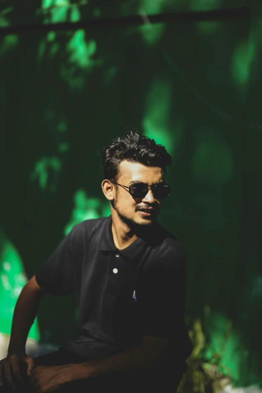 a man sitting in the shade of a tree, by Max Dauthendey, pexels contest winner, hurufiyya, in a dark green polo shirt, discord profile picture, wearing cool sunglasses, hindu aesthetic