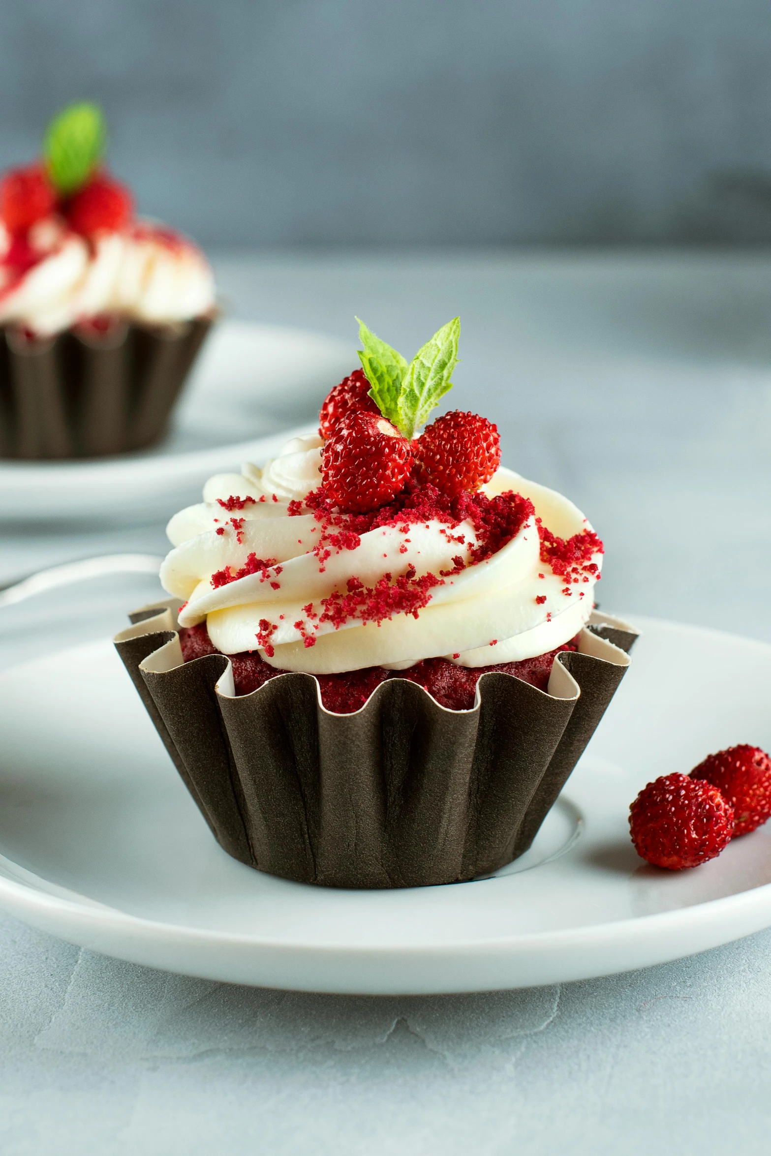 a couple of cupcakes sitting on top of a white plate, raspberries, dressed in red paper bags, davinci, mint