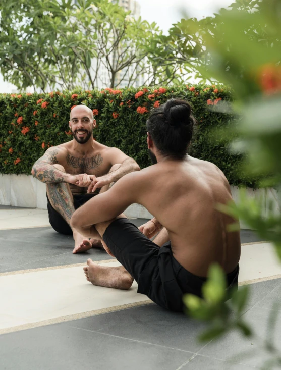 a couple of men sitting on top of a yoga mat, a tattoo, thawan duchanee, profile image, lush surroundings, lgbt