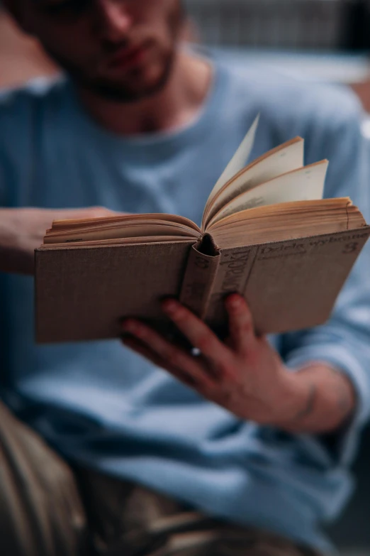 a man sitting on a couch reading a book, pexels contest winner, renaissance, pictured from the shoulders up, mechanics, close body shot, words