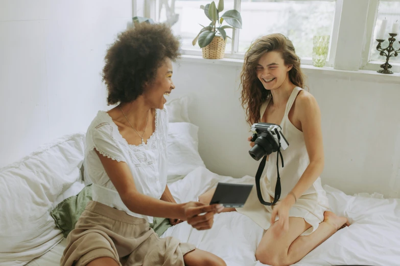 a couple of women sitting on top of a bed, a polaroid photo, pexels contest winner, happening, avatar image, calmly conversing 8k, ad image, wearing white camisole