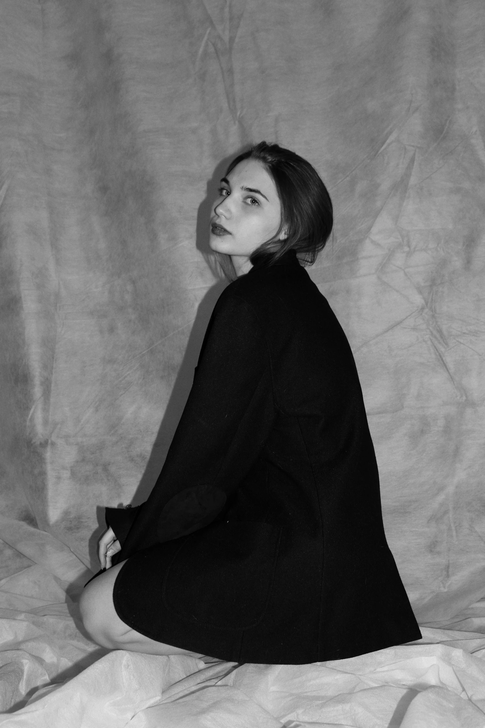 a black and white photo of a woman sitting on a bed, inspired by August Sander, tumblr, realism, billie eilish as a nun, kiko mizuhara, elegant profile pose, lily collins