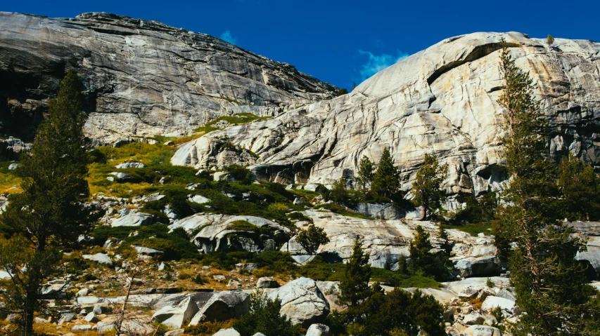 a mountain covered in lots of rocks and trees, unsplash, figuration libre, central california, promo image, marble walls, campsites