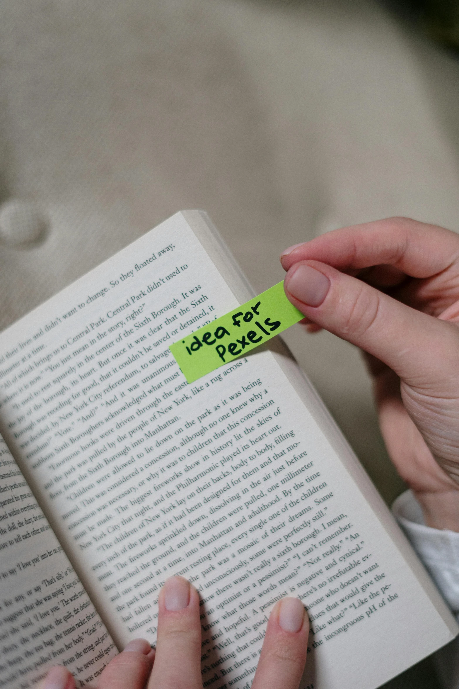 a close up of a person holding a book, green: 0.25, sticky, highlight, detail shot