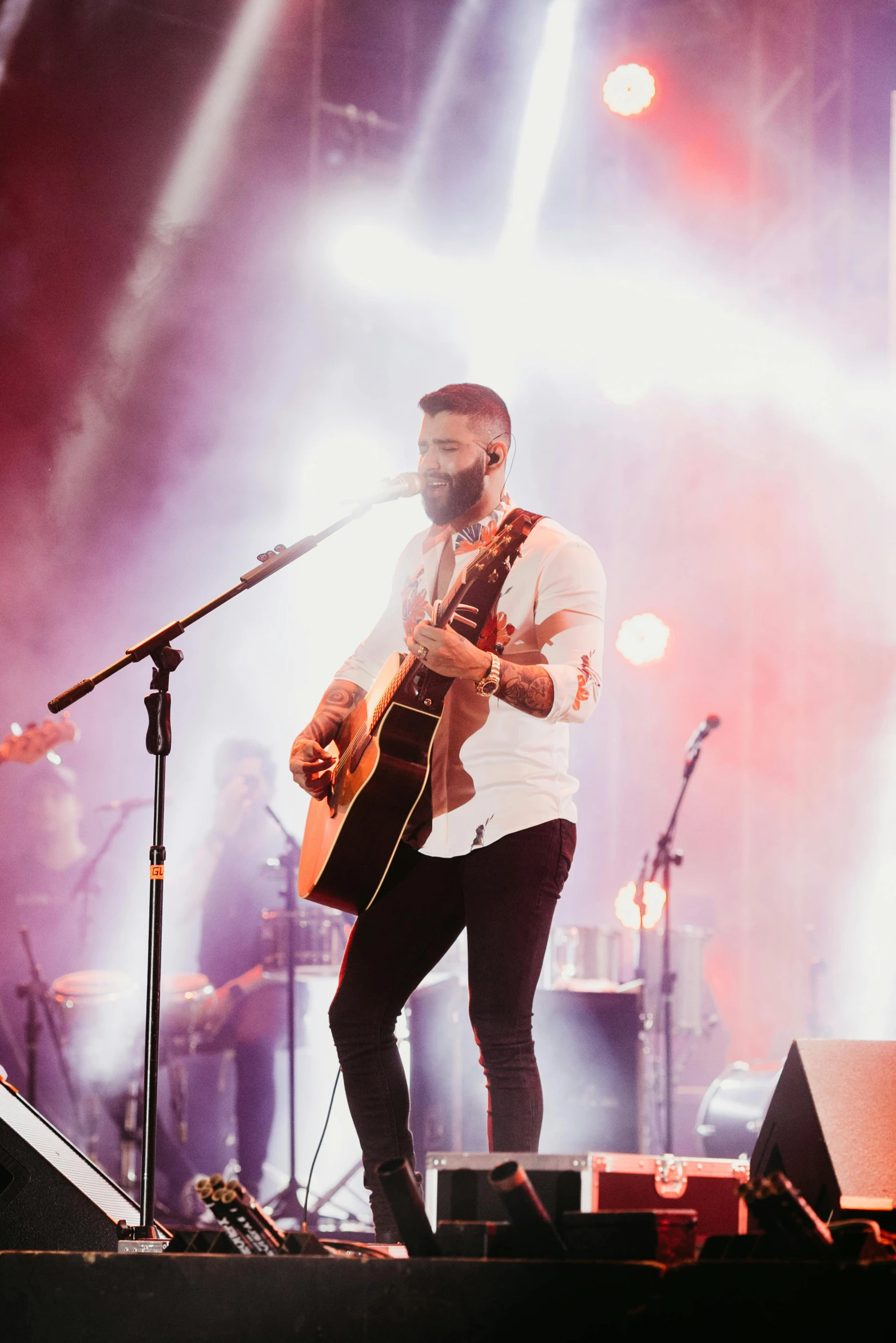 a man that is standing on a stage with a guitar, trending on pexels, bearded beautiful man, holy lights, zachary corzine, meadows