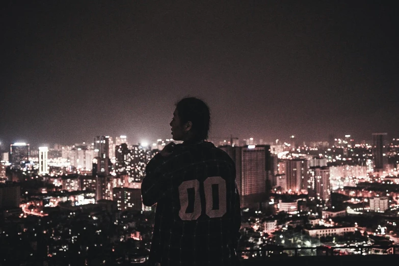 a man looking out over a city at night, pexels contest winner, happening, streetwear, ☁🌪🌙👩🏾, cover photo portrait of du juan, pictured from the shoulders up