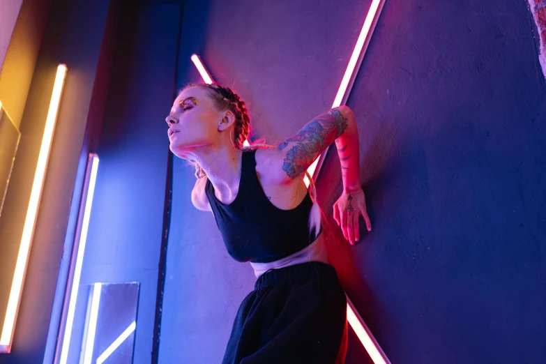 a woman leaning against a wall with neon lights, pexels contest winner, light and space, resembling a mix of grimes, female dancer, alana fletcher, jamie coreth