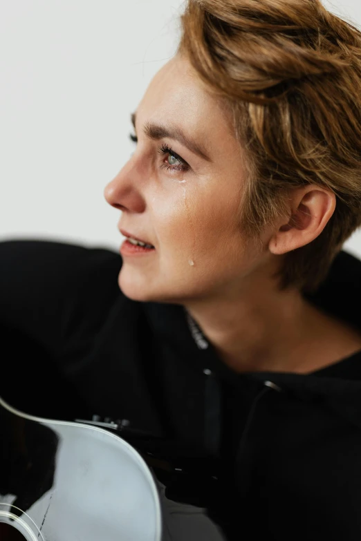 a close up of a person holding a guitar, androgynous face, profile image, overview, heartbroken