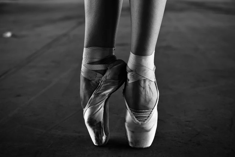 a black and white photo of a pair of ballet shoes, by Elizabeth Polunin, arabesque, standing, sweat, getty images, sergey vasnev