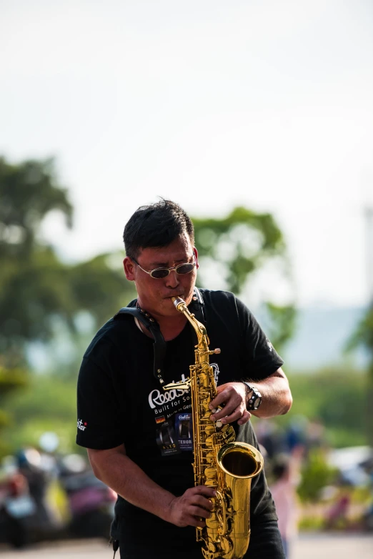 a man in a black shirt playing a saxophone, by Reuben Tam, park in background, hoang long ly, avatar image, headshot