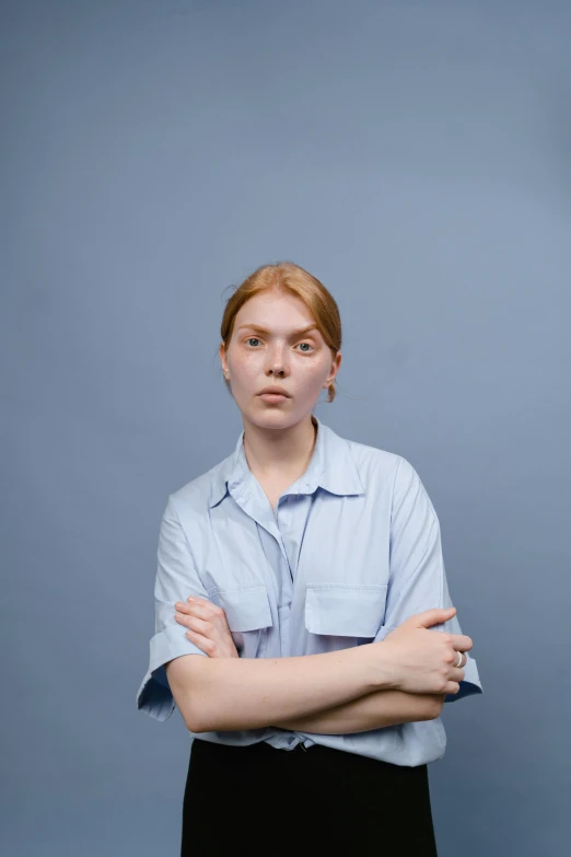 a woman standing with her arms crossed, by Tobias Stimmer, trending on reddit, wearing a light blue shirt, non binary model, hr ginger, photo taken in 2 0 2 0