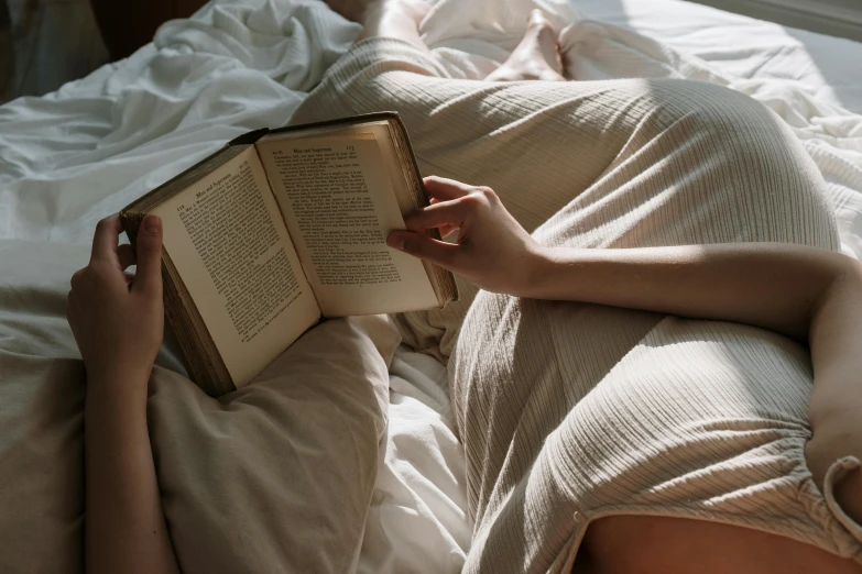 a woman laying in bed reading a book, pexels contest winner, dirty linen robes, instagram post, julia sarda, bedhead