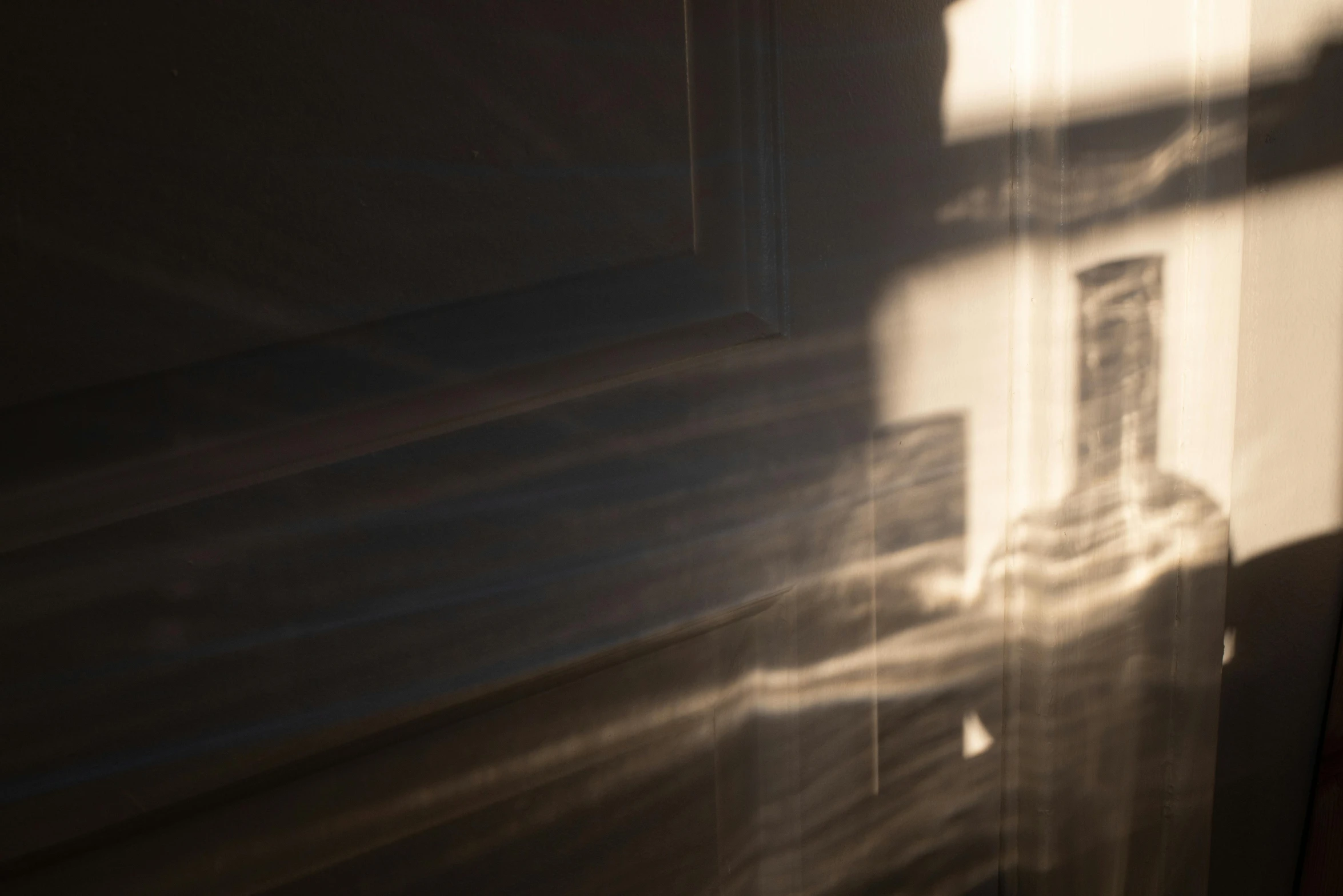 a cat laying on top of a bed next to a window, inspired by Anna Füssli, unsplash, light and space, volumetric dust rays, shadow of catholic church cross, refracted light, abstract photography