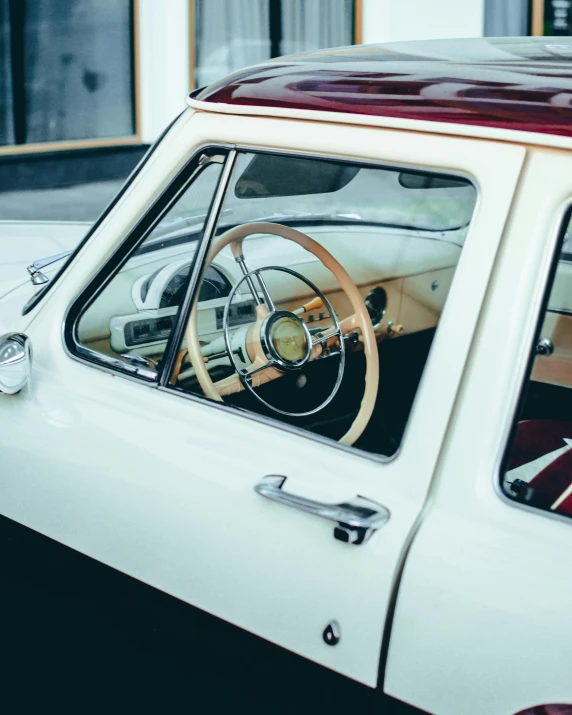 a red and white car parked in front of a building, trending on unsplash, hypermodernism, 1 9 7 0 s car window closeup, square, steering wheel, cream and white color scheme