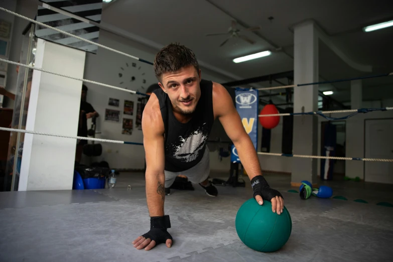 a man doing push ups on a ball in a boxing ring, a portrait, by Meredith Dillman, dribble, lachlan bailey, looking towards camera, sam nassour, profile photo