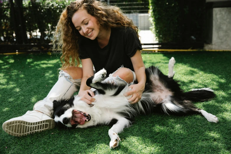 a woman playing with a dog on the grass, pexels contest winner, happening, both laughing, laying on the ground, aussie, holding paws