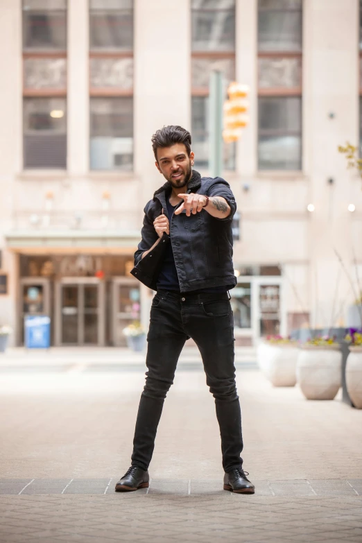 a man standing in the middle of a street pointing at the camera, by Adam Dario Keel, wolverine action pose, musician, profile image, black in