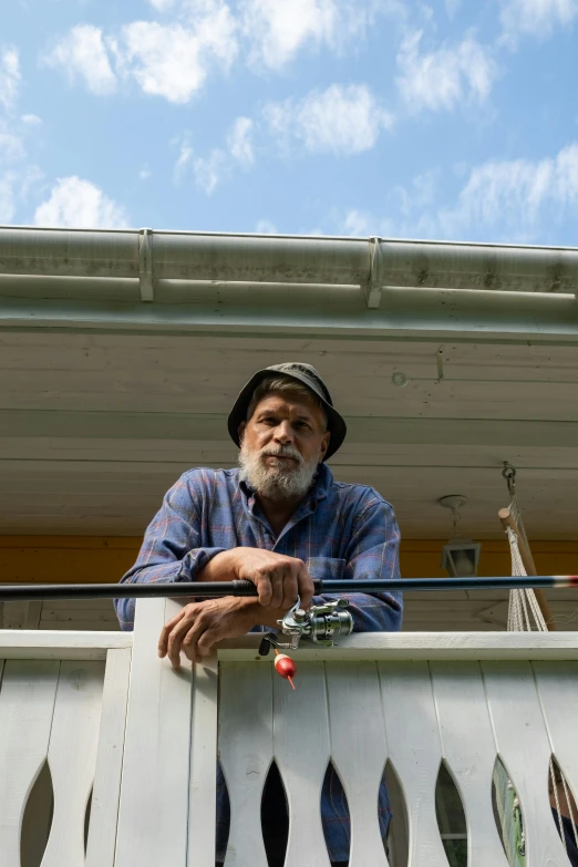 a man standing on a balcony with a fishing rod, a portrait, by Peter Churcher, full frame image, farmer, bearded, dingy