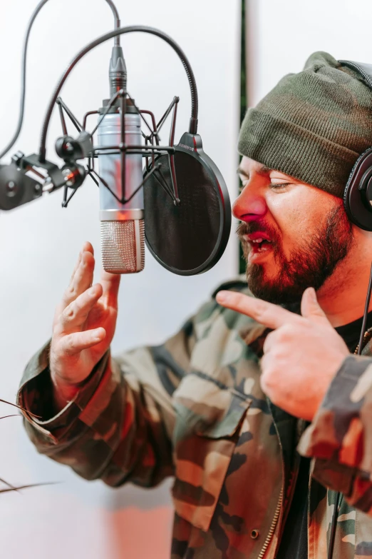 a man wearing headphones in front of a microphone, an album cover, trending on pexels, wearing camo, neckbeard, in a studio, dialogue