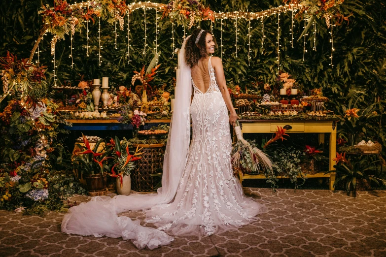 a woman in a wedding dress standing in front of a table, pexels contest winner, tropical vibe, middle eastern style vendors, fairy lights, arched back