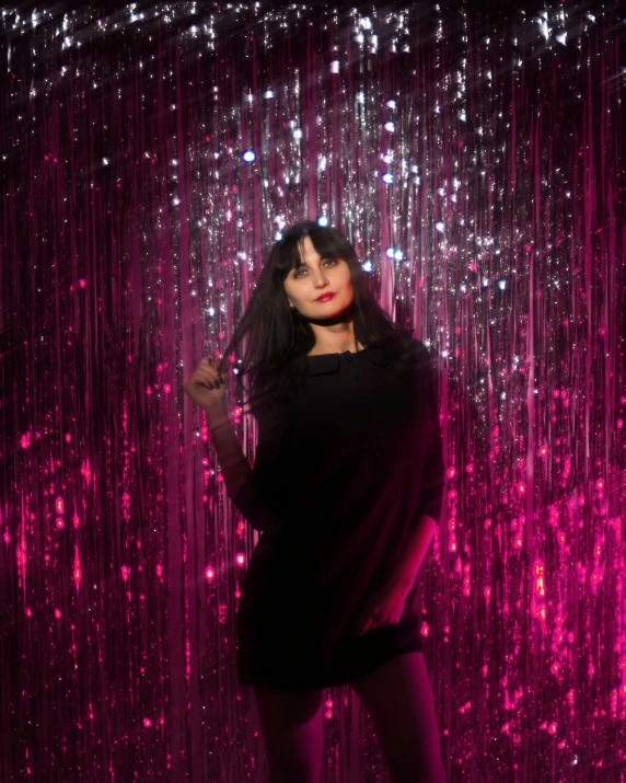 a woman standing in front of a pink curtain, an album cover, pexels contest winner, holography, long black hair with bangs, waves of lights, ana de la reguera portrait, bisexual lighting