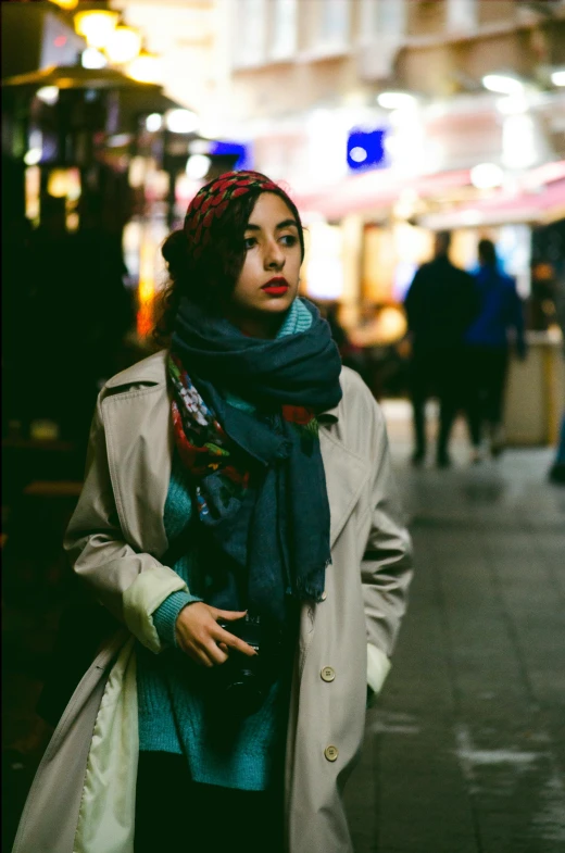 a woman standing on a city street at night, trending on pexels, hurufiyya, head scarf, imogen poots, korean woman, long coat