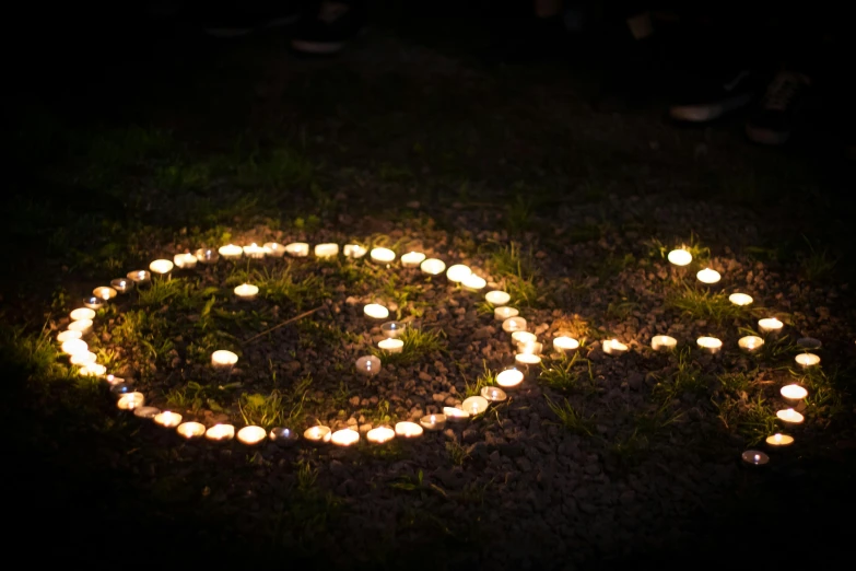 candles are arranged in the shape of a smiley face, by Bruce Munro, pixabay, land art, light casting onto the ground, enso, shot with canon eoa 6 d mark ii, smokey burnt love letters