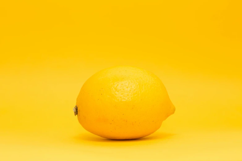 a close up of a lemon on a yellow background, unsplash, low quality photo, taken with canon 5d mk4, album, plump