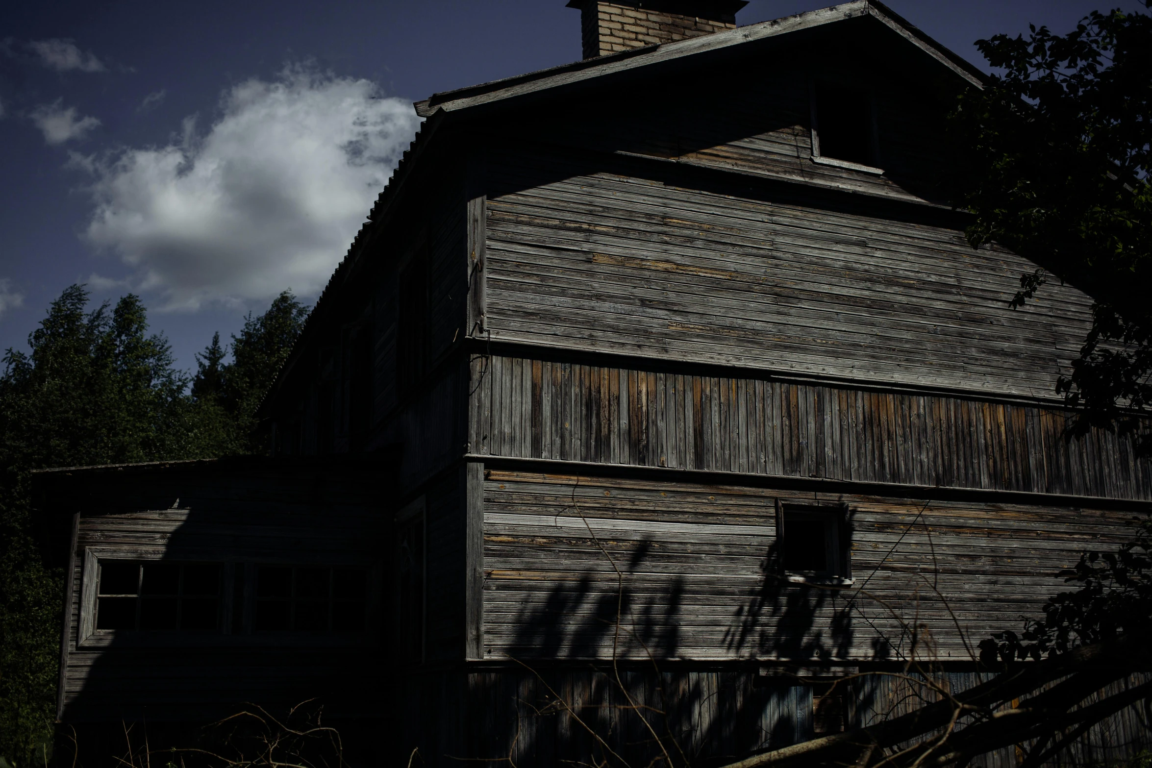 a large wooden building sitting in the middle of a forest, inspired by Gregory Crewdson, unsplash, renaissance, with ominous shadows, alpine architecture, medium format. soft light, farmhouse