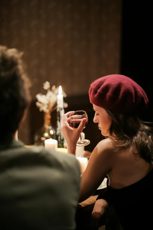 a man and a woman sitting at a table with wine glasses, trending on pexels, renaissance, wearing a french beret, ambience lighting, cosy, brunette