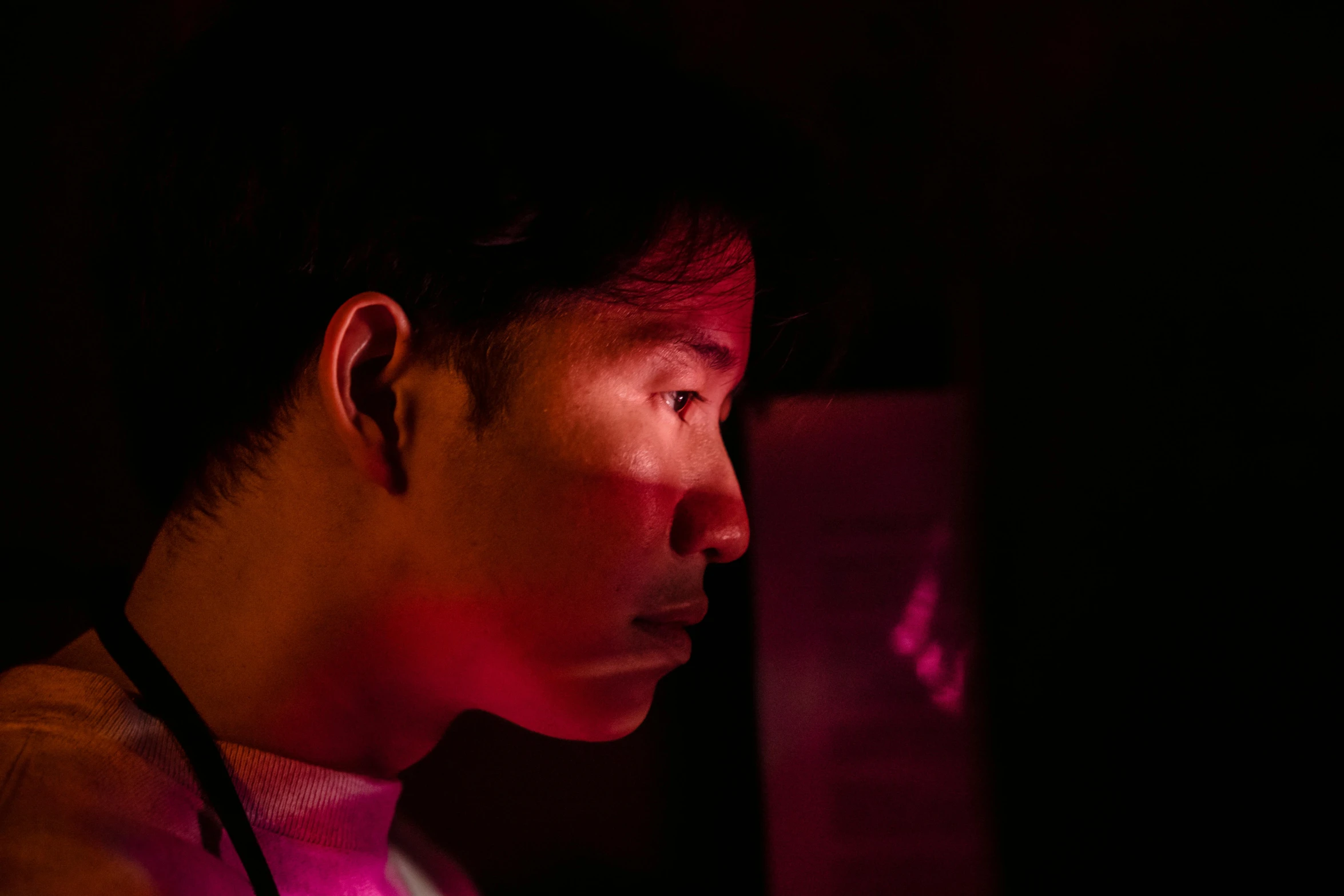 a man sitting in front of a laptop computer, pexels contest winner, realism, glowing magenta face, wenjun lin, soft light from the side, looking into a mirror
