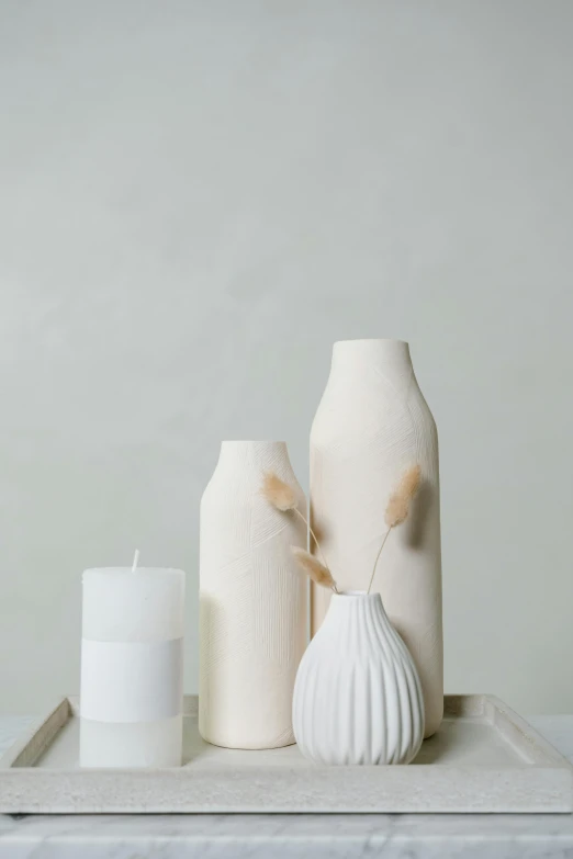 a tray topped with vases and candles on top of a table, inspired by Giorgio Morandi, trending on unsplash, folk art, matte white background, white sweeping arches, textured base ; product photos, beautifully soft lit