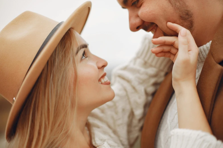 a man and a woman are looking into each other's eyes, trending on pexels, woman with hat, warm and gentle smile, thumbnail, ad image