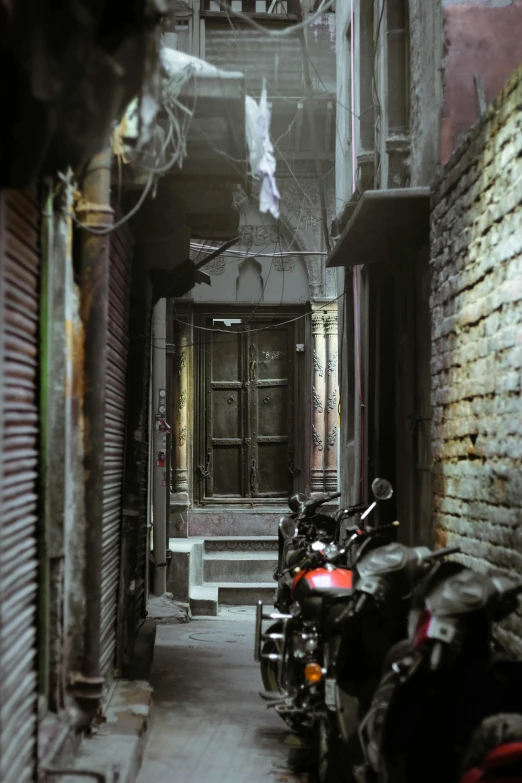 a row of motorcycles parked next to a building, a detailed matte painting, inspired by Steve McCurry, conceptual art, in an alley at night back lit, hindu, doorway, intricate environment - n 9