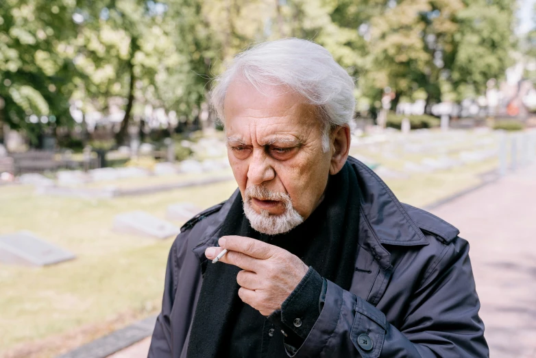 an older man smoking a cigarette in a cemetery, pexels contest winner, offering the viewer a pill, looking confused, meni chatzipanagiotou, white-haired