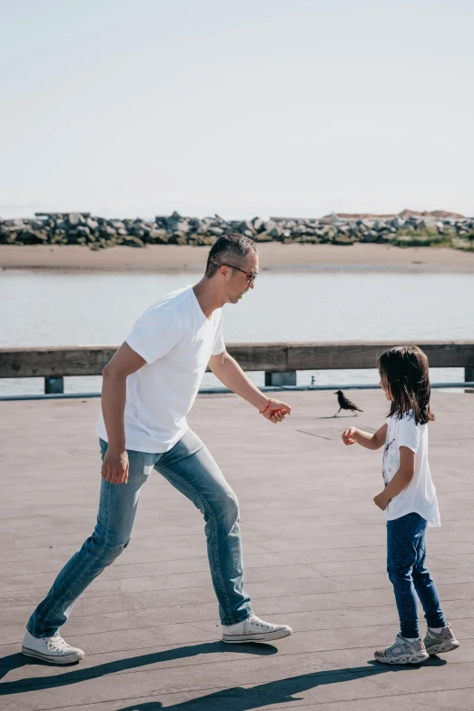 a man and a little girl playing with a kite, pexels contest winner, happening, near a jetty, jeans and t shirt, playing basketball, bay area