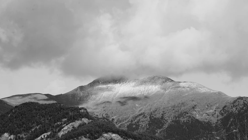 a black and white photo of a snow covered mountain, by Emma Andijewska, low clouds after rain, detailed 4 k photo, in muted colours, portrait of gigachad